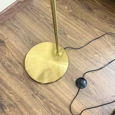 Lámpara de pie metal dorada.